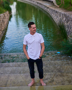 Rear view of young man standing in water