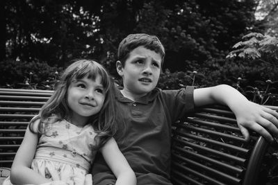 Portrait of mother and girl sitting outdoors