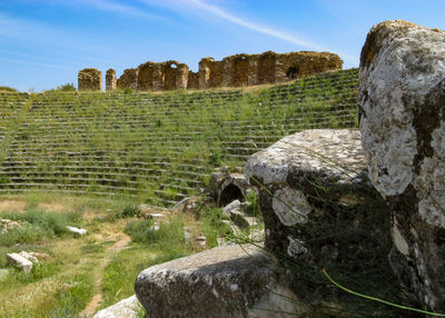 Stone wall on field against sky