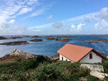 Houses on beach by sea against sky