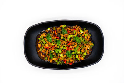 High angle view of vegetables in bowl against white background