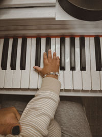 Cropped photo of woman holding baby while baby is playing piano