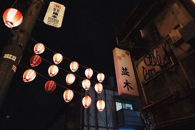 Low angle view of illuminated lanterns hanging at night