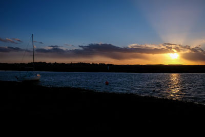 Silhouette boats sailing in sea against sky during sunset