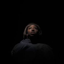 Portrait of a serious young man over black background