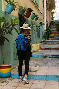 Rear view of woman standing by potted plants