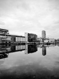 Reflection of buildings in river against sky