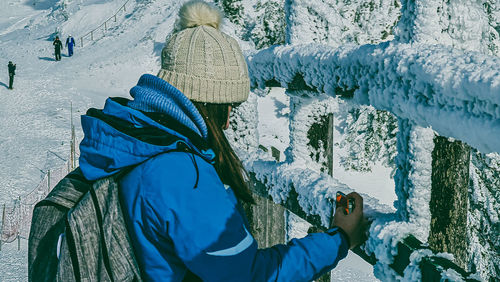 Rear view of man on snow covered mountain