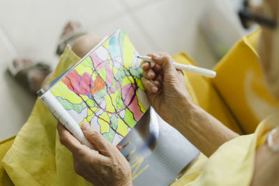 Woman drawing in book at home