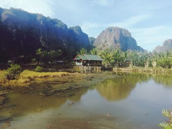 Scenic view of lake by houses against sky