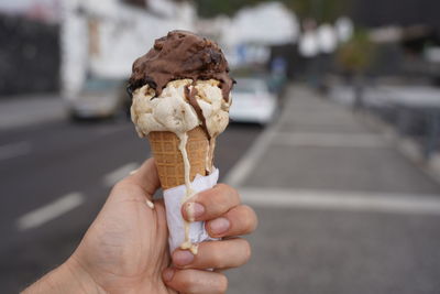 Close-up of hand holding ice cream cone