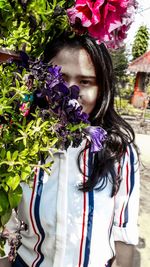 Portrait of woman standing against purple flowering plants
