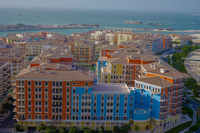 High angle view of townscape by sea against sky