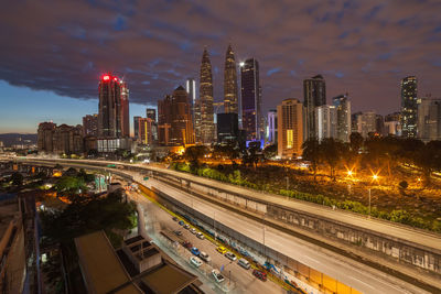 Illuminated buildings in city against sky