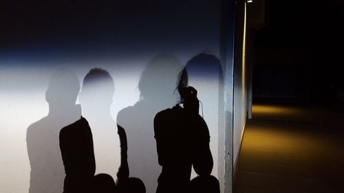 Silhouette people standing against sky at night