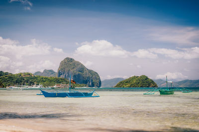 Traditional banca boat on sandy corong corong beach in el nido, philippines.