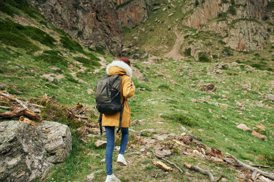 Rear view of man walking on rock