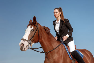 Portrait of young woman riding horse