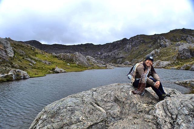 water, rock - object, sky, mountain, leisure activity, lifestyles, sitting, full length, nature, cloud - sky, rock, standing, tranquility, rock formation, beauty in nature, scenics, casual clothing, men