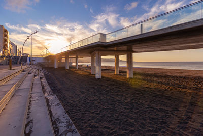 Bridge over sea against sky during sunset