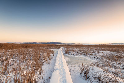 Rural winter landscape. sunrise over snowy road.