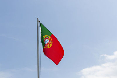 Low angle view of flag against blue sky