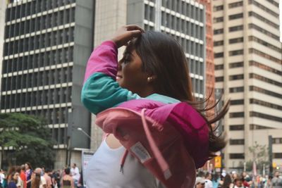 Rear view of women standing on street in city