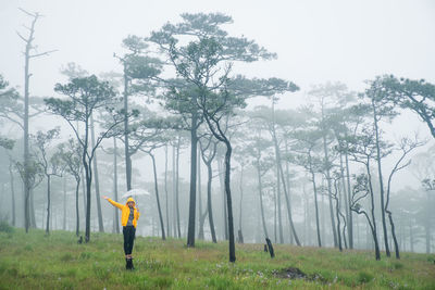 Man standing on field against trees