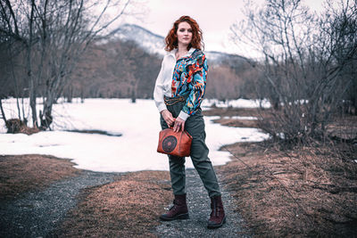 Full length of woman standing on snow covered tree