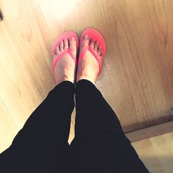 Low section of woman standing on hardwood floor