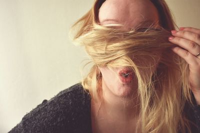 Close-up portrait of woman against wall