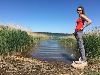 Full length of woman standing on field against sky