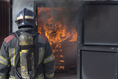 Rear view of firefighter working outdoors