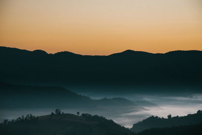 Scenic view of silhouette mountains against sky during sunset