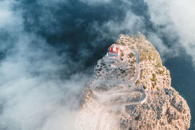 Directly above shot of lighthouse on mountain by sea in foggy weather