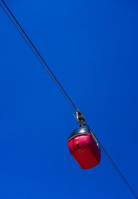 Low angle view of telephone pole against clear blue sky