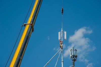 Low angle view of cranes against sky