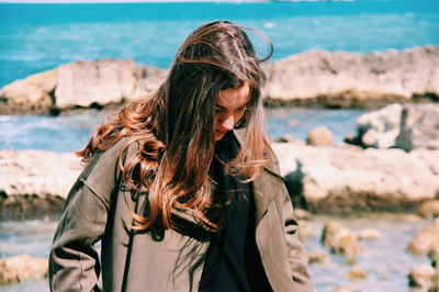 Close-up of young woman standing at beach