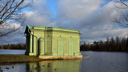 Built structure by lake against sky