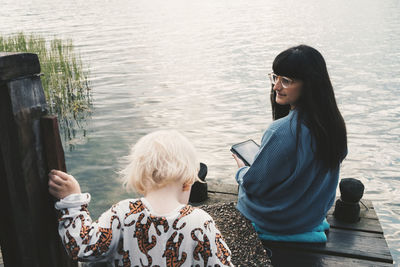 Rear view of couple sitting on water