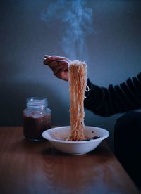 Cropped image of hand holding noodles