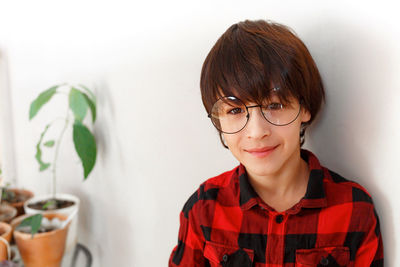 Portrait of smiling woman against wall