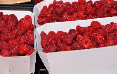 High angle view of raspberries in cardboard boxes for sale at market
