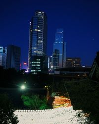Illuminated city against clear sky at night