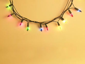 Colorful illuminated string lights hanging on wall at night