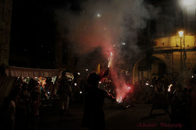 Man with firework display during event at night