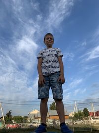 Full length of boy standing against sky