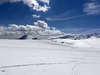 Scenic view of snow covered mountains against blue sky