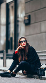 Portrait of young woman sitting outdoors