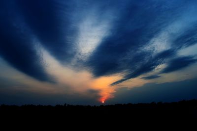 Scenic view of silhouette landscape against dramatic sky